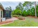 Manicured backyard featuring lush landscaping and a screened lanai for outdoor enjoyment at 5004 Sandy Brook Cir, Wimauma, FL 33598