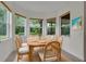 Bright dining area featuring a wood table, seating for six, and large windows providing natural light and outdoor views at 5004 Sandy Brook Cir, Wimauma, FL 33598