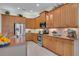 Well-lit kitchen featuring stainless steel appliances, granite countertops, and ample wooden cabinetry at 5004 Sandy Brook Cir, Wimauma, FL 33598