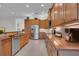 Spacious kitchen with stainless steel appliances, plentiful wooden cabinets, and tile backsplash at 5004 Sandy Brook Cir, Wimauma, FL 33598