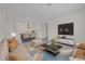 Bright, open-concept living and dining area featuring a modern chandelier and a large television at 5004 Sandy Brook Cir, Wimauma, FL 33598