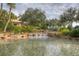 Beautiful water feature surrounded by lush landscaping and mature trees in the community at 5004 Sandy Brook Cir, Wimauma, FL 33598