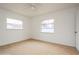 Bright bedroom featuring neutral carpeting and two windows at 51 Lexington Dr, Dunedin, FL 34698