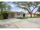 Charming single-story home with a carport and well-manicured front yard, enhanced by mature trees and neighborhood charm at 51 Lexington Dr, Dunedin, FL 34698