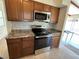 This kitchen features a stainless steel oven, microwave, and brown cabinets at 51 Lexington Dr, Dunedin, FL 34698