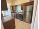 This kitchen features a stainless steel refrigerator, dishwasher, and brown cabinets at 51 Lexington Dr, Dunedin, FL 34698