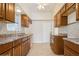 This kitchen features brown cabinets, tile countertops, and stainless steel double sinks at 51 Lexington Dr, Dunedin, FL 34698