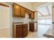This kitchen features tile countertops, brown cabinets, and tiled backsplash at 51 Lexington Dr, Dunedin, FL 34698