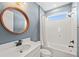 Stylish bathroom with a shower-tub combo, a wood-trimmed mirror, and updated fixtures in a calming blue color scheme at 6232 Sea Air Dr, Apollo Beach, FL 33572