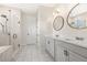 Elegant bathroom with a glass-enclosed shower, double vanity with modern fixtures, and marble-look tile flooring at 6232 Sea Air Dr, Apollo Beach, FL 33572