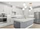 Modern kitchen with white cabinetry, stainless steel appliances, a large island, and stylish pendant lighting at 6232 Sea Air Dr, Apollo Beach, FL 33572