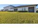 Green backyard featuring manicured bushes, an expansive lawn, and a view of the home's screened-in patios at 10374 Echo Dock Loop, San Antonio, FL 33576