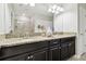 Bathroom featuring double sinks, granite countertops, and modern fixtures beneath a large mirror at 10374 Echo Dock Loop, San Antonio, FL 33576