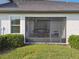 Screened-in patio exterior with outdoor seating, offering a relaxing space in a well-maintained yard at 10374 Echo Dock Loop, San Antonio, FL 33576