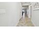 Neutral hallway leading to open floor plan, showcasing natural light and modern tile flooring at 10374 Echo Dock Loop, San Antonio, FL 33576