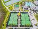 Aerial view of community tennis courts, bocce ball courts, and pool with sun loungers and palm trees at 10374 Echo Dock Loop, San Antonio, FL 33576