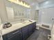 Modern bathroom features blue vanity with white counter, mirror and gray tile flooring at 11199 Warm Wind Way, Weeki Wachee, FL 34613