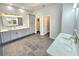 Bright bathroom features double vanity, gray cabinets, stone countertops, and modern tile flooring at 11199 Warm Wind Way, Weeki Wachee, FL 34613