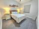 Bright bedroom with woven headboard, side tables, and gray tile flooring at 11199 Warm Wind Way, Weeki Wachee, FL 34613