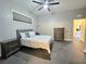 Bedroom features gray and white bedding, a ceiling fan and gray tile flooring at 11199 Warm Wind Way, Weeki Wachee, FL 34613