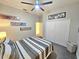 Bedroom features gray and white bedding, a ceiling fan, and art adorning the walls at 11199 Warm Wind Way, Weeki Wachee, FL 34613