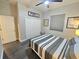 Cozy bedroom with closet, window, ceiling fan, and gray and white bedding at 11199 Warm Wind Way, Weeki Wachee, FL 34613