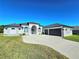 Stunning home featuring a manicured lawn, a wide driveway, and an attached three-car garage at 11199 Warm Wind Way, Weeki Wachee, FL 34613