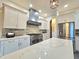 The kitchen has stainless steel appliances, white cabinets, and quartz countertops at 11199 Warm Wind Way, Weeki Wachee, FL 34613