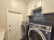 Laundry room with large washer and dryer with white cabinets and blue accent wall at 11199 Warm Wind Way, Weeki Wachee, FL 34613