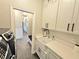 View of laundry room with sink, cabinets, and washer dryer with mudroom leading to hallway at 11199 Warm Wind Way, Weeki Wachee, FL 34613