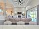 Bright and airy living room, with a vaulted ceiling, ceiling fan, a fireplace, and patio doors at 11199 Warm Wind Way, Weeki Wachee, FL 34613