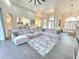 Open-concept living room featuring tile flooring, a large sectional sofa, and views into the kitchen at 11199 Warm Wind Way, Weeki Wachee, FL 34613