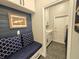 Mudroom with storage bench, dark blue accent wall, and access to laundry room at 11199 Warm Wind Way, Weeki Wachee, FL 34613