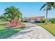 Stunning single-story home boasts a terracotta roof, lush landscaping, and a winding driveway at 1575 Brookside Blvd, Largo, FL 33770