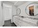 Modern bathroom with dual sinks, granite countertops, black floors, and an open walk-in closet at 6327 2Nd S Ave, St Petersburg, FL 33707
