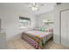 Cozy bedroom with tile floor, colorful bedding, and natural light from two windows at 6327 2Nd S Ave, St Petersburg, FL 33707