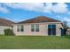 A lush green backyard featuring sliding glass doors, windows, and a well-manicured lawn at 814 Fern Leaf Dr, Ruskin, FL 33570
