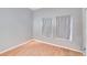 Bedroom with wood-look flooring, neutral paint, and two windows with curtains, offering a bright and airy space at 814 Fern Leaf Dr, Ruskin, FL 33570