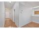 Hallway features wood-look floors leading to the front door, with a view of the kitchen in the background at 814 Fern Leaf Dr, Ruskin, FL 33570