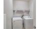 Laundry room with white washer and dryer, wire shelving for storage, and neutral paint at 814 Fern Leaf Dr, Ruskin, FL 33570