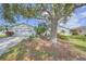 Charming single-story home with an attached garage, a well-manicured lawn, and mature trees at 1318 Leland Dr, Sun City Center, FL 33573