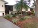 Landscaped front yard featuring a palm tree, various plants, and a walkway leading to the home at 1318 Leland Dr, Sun City Center, FL 33573