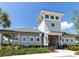 Community clubhouse with covered patio, manicured landscaping, and tower feature at 30160 Skylark Dr, Wesley Chapel, FL 33545