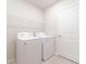 Bright laundry room with appliances and white shelving for storage at 30160 Skylark Dr, Wesley Chapel, FL 33545