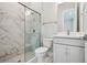 Bathroom with white vanity, toilet, glass enclosed shower with marble tile, and modern fixtures at 6123 Hidden Branch Dr, Apollo Beach, FL 33572