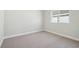 Clean and simple bedroom featuring neutral carpet, crisp white walls, and a window for natural light at 6123 Hidden Branch Dr, Apollo Beach, FL 33572