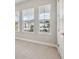Bright bedroom with plush carpet and a set of windows offering exterior views of the neighborhood at 6123 Hidden Branch Dr, Apollo Beach, FL 33572