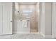 Modern shower stall with marble tile, frameless glass enclosure, window and a mounted towel bar at 6123 Hidden Branch Dr, Apollo Beach, FL 33572