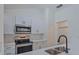 Bright kitchen features stainless steel appliances, white cabinets, and modern fixtures at 102 Shoreview Ln, Oldsmar, FL 34677