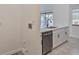 Kitchen area showcasing stainless steel dishwasher and a sink with white cabinets at 102 Shoreview Ln, Oldsmar, FL 34677